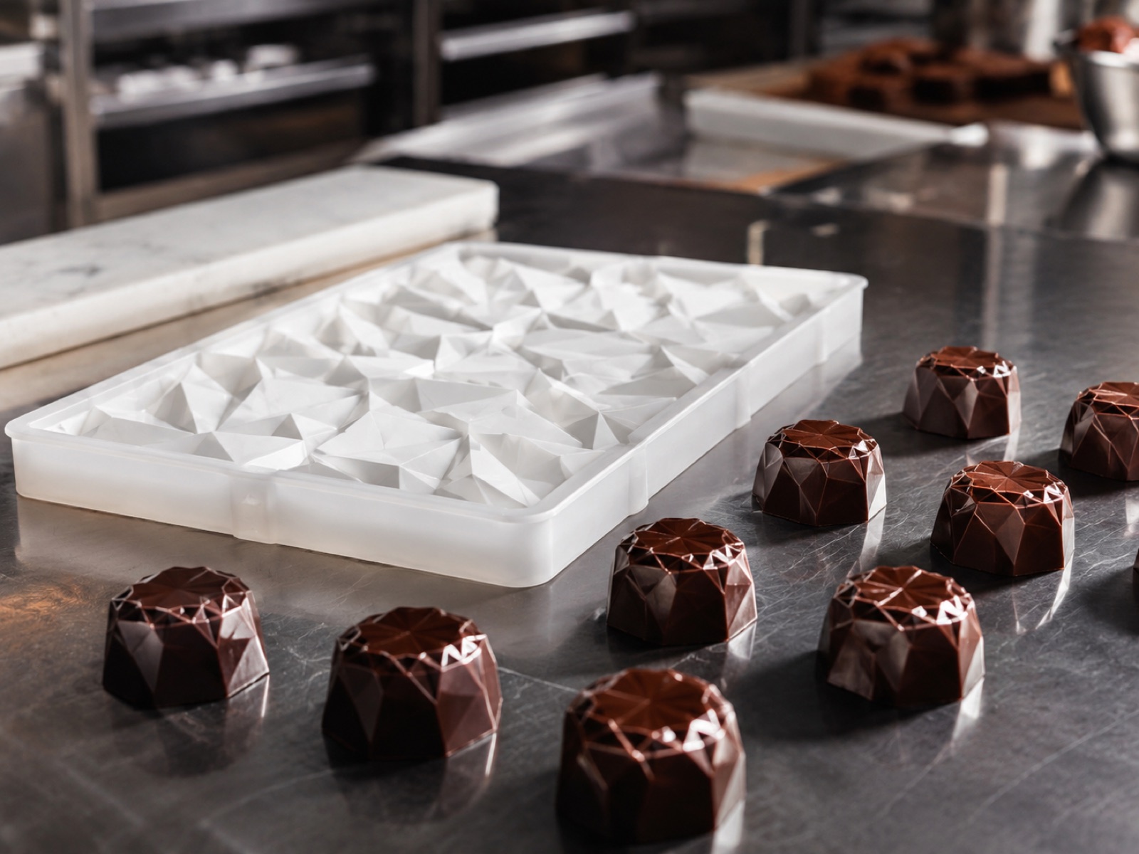 Moule alimentaire imprimé en 3D à côté de chocolats moulés